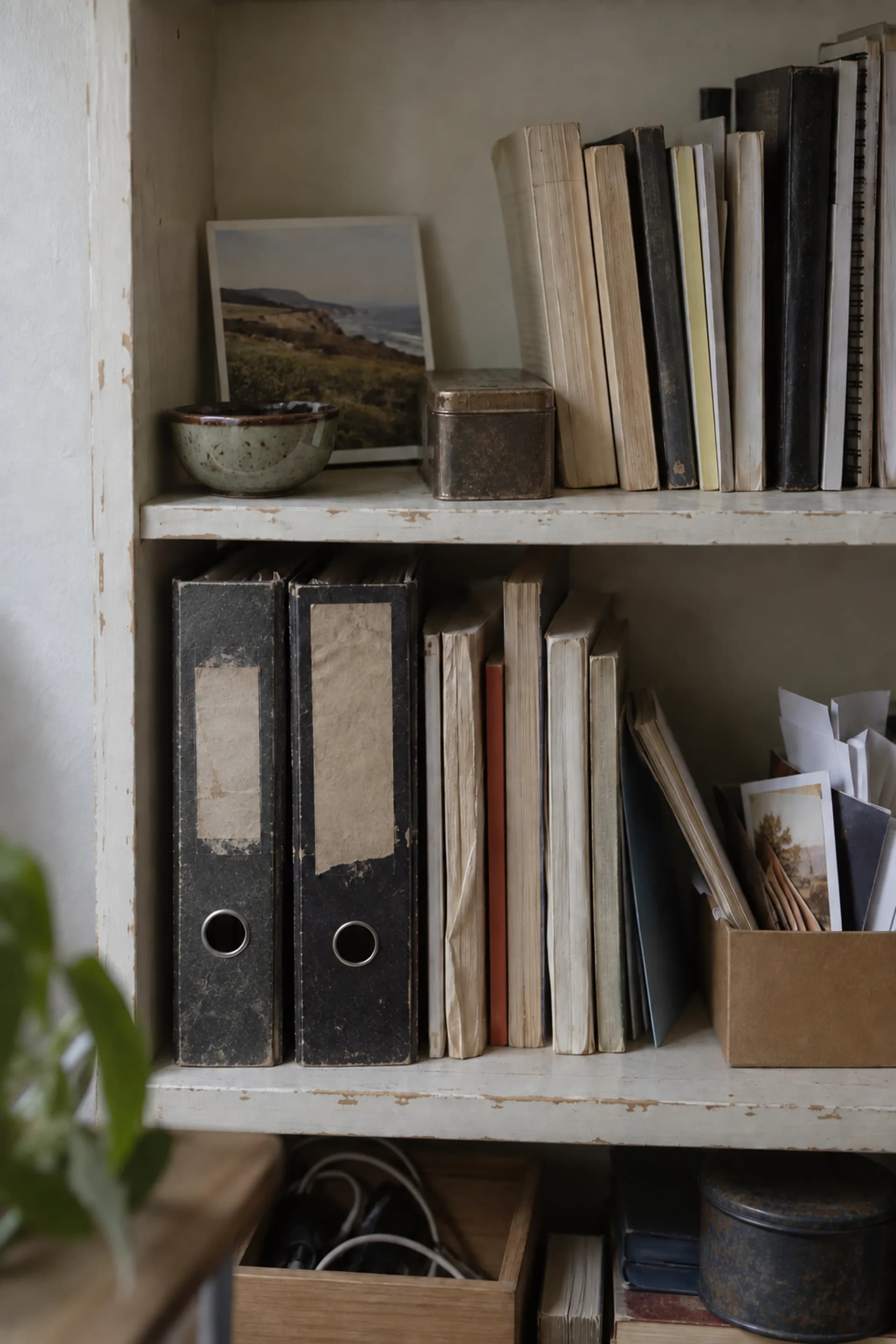 Une étagère de carnets et de livres dans la lumière du jour.